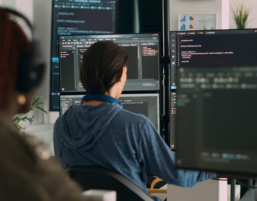 Database programer writing code on terminal window using multiple monitors in it agency office. System software developer typing database information, computing big data script.